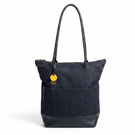 Large denim and black leather tote handbag by R. Riveter, featuring sturdy handles and spacious interior for everyday use.